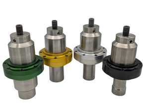 A set of four titanium solid mount boosters, each with a different color accent (green, gold, silver, black) on the upper part.